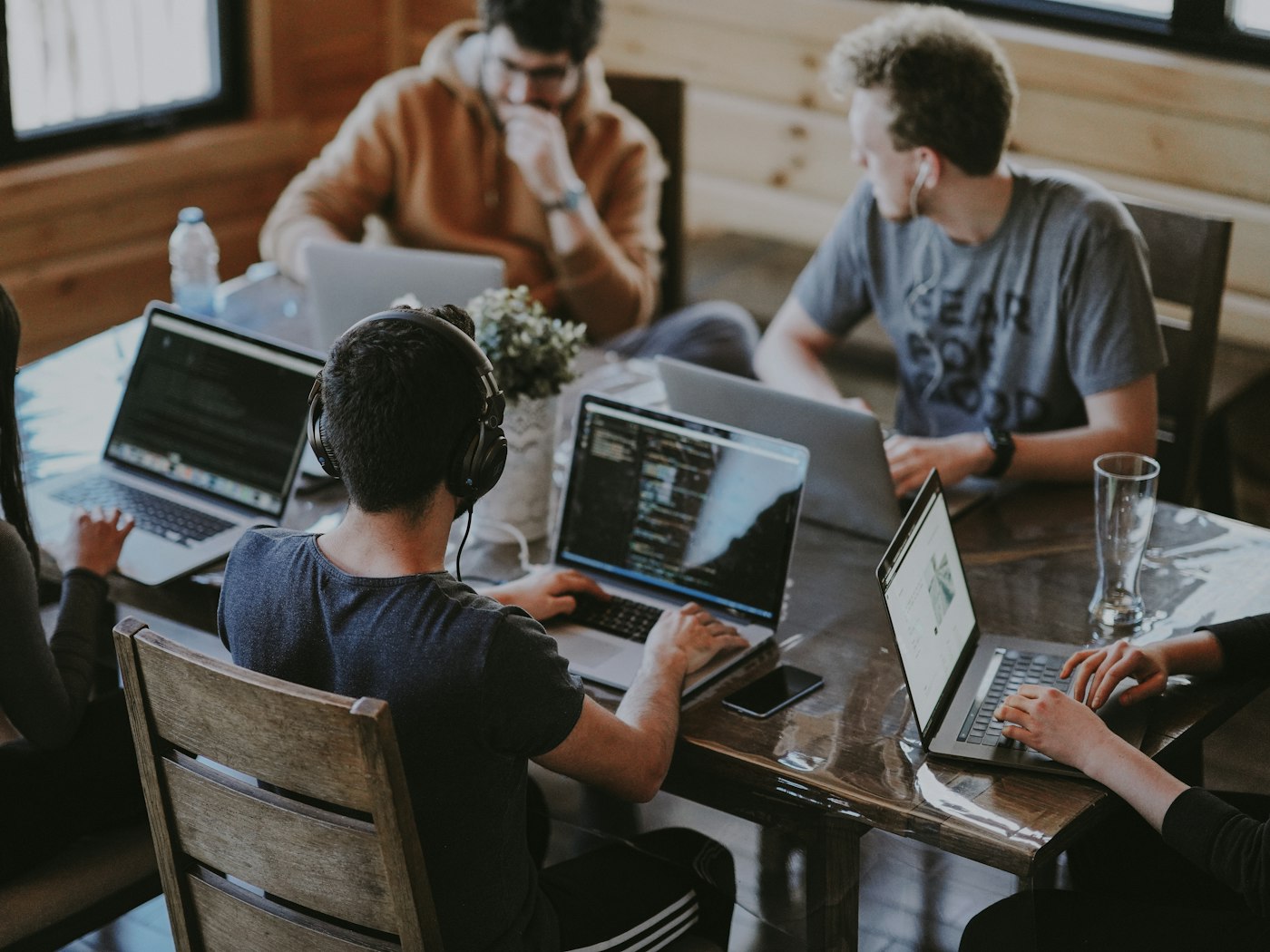 A small product team working together around a table of laptops